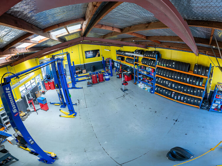 Wide view of the Hamilton Auto Centre workshop with tyre racks and vehicle hoists