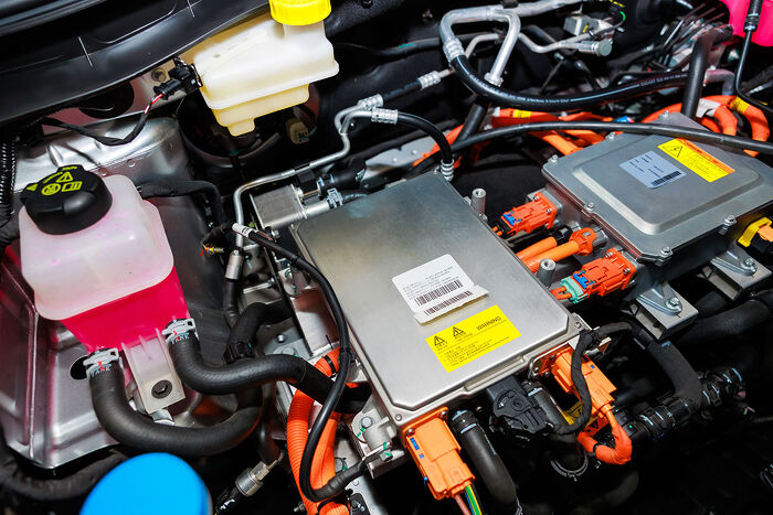 Close-up of electric vehicle engine components and wiring inside the bay